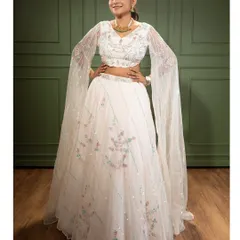 This elegant white lehenga features delicate floral embroidery and dramatic flared sleeves. It’s a timeless piece that is perfect for an engagement party or a sophisticated reception look.