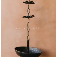 An artistic shot of a traditional brass lamp, a detail from a South Indian wedding decor. The warm tones and minimalist composition highlight the beauty in the small elements.