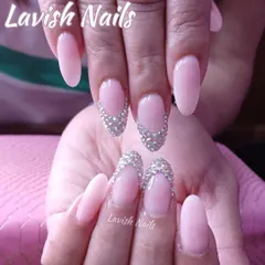 An incredibly glamorous set of long, almond-shaped nails. This design features a soft pink base with accent nails in a V-shape, completely encrusted with sparkling rhinestones for a dazzling, diamond-like effect.