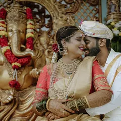 A quiet, happy moment between the bride and groom during their traditional South Indian wedding ceremony in Bangalore. I focus on capturing these genuine connections, blending candid photography with the richness of the cultural setting, like the ornate Ganesha sculpture in the background.