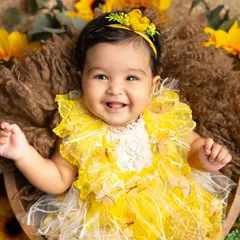 A perfect three-month milestone photo. This baby girl's happy smile, captured in a basket surrounded by sunflowers, is a beautiful memory of this fleeting stage.