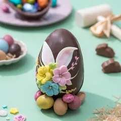 My signature Piñata Egg for Easter, a large chocolate egg decorated with delicate sugar flowers and bunny ears, ready to be smashed open. It's an interactive treat that holds a surprise of mini chocolates inside.