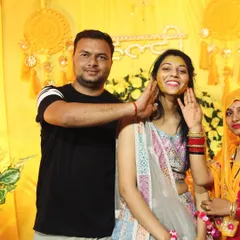 A family member playfully applies haldi to the smiling bride. Our goal is to be right in the middle of the action to capture these authentic interactions during the ceremony.
