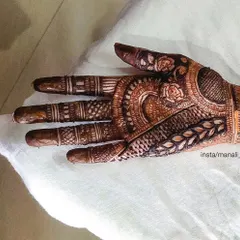 This is a detailed look at the palm of a traditional design. You can see the fine line work, shading, and different motifs like roses and leaves that come together to create a rich texture.
