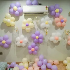 Simple yet charming balloon flower decorations on a wall. These pastel-colored balloon flowers are a great way to add a touch of whimsy to any room for a birthday celebration.
