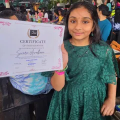 Another young performer holds her certificate after our concert. These moments of recognition are crucial for building the confidence of our little rockstars.