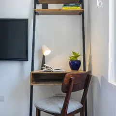 A closer look at the ladder-style study desk. This space-saving solution is perfect for apartment living, offering shelving for books and a neat work surface, all while maintaining a light and open feel.