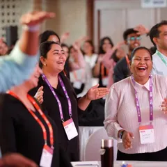 Beyond the stage, we focus on the human element. This candid shot captures the genuine laughter and enjoyment of attendees during a conference session, highlighting our skill in documenting the authentic atmosphere of an event.