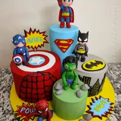 Avengers, assemble! This multi-cake setup brings together the mightiest heroes for an epic birthday. Each cake represents a different Avenger, from Captain America's shield and Spider-Man's web to Batman's Gotham and Hulk's smash, all topped with cute, chibi-style hero figurines.