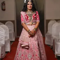 The bride-to-be looking radiant in her pink engagement lehenga. The makeup is glamorous yet elegant, with defined eyes and a matching pink lip tone.