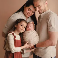 A beautiful family portrait with a big sister proudly helping to hold her new baby sibling. These are the memories that they will look back on and cherish for years to come.