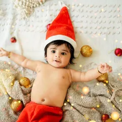 A jolly baby in a Santa hat, surrounded by festive lights and ornaments. These simple, joyful setups are perfect for capturing your baby's first Christmas.