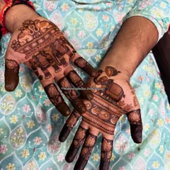 A groom's mehandi filled with royal motifs. His hands are adorned with majestic elephants and elegant peacocks, symbols of strength, prosperity, and timeless tradition.