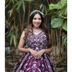 This wine-coloured ball gown is pure elegance, featuring intricate floral handwork across the bodice. Paired with a delicate tiara and necklace, it creates a regal look perfect for a bride's reception or a formal gala.
