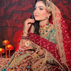 A full-length view of the stunning bridal attire. The hairstyle is kept classic with soft waves to balance the heavy jewelry and intricate embroidery of the lehenga.