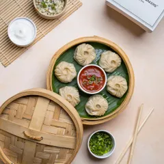 Our round steamed momos, filled with a savory vegetable mixture and served with our signature spicy dipping sauce. The bamboo steamer keeps them hot and moist until they reach your table.