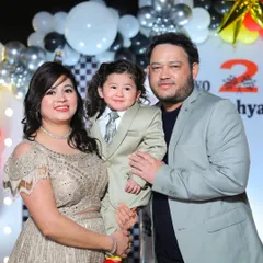 A happy family of three poses for a photo during their son's second birthday party. I make sure to get those classic posed shots amidst all the event's excitement.