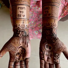 A beautiful example of a full baby shower design featuring a couple portrait on one palm. The other hand is decorated with baby themed symbols, and the forearms carry the proud announcement of "Mom to Be" and "Dad to Be".