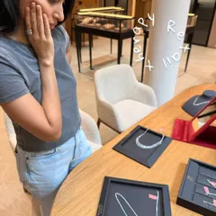 The joy of finding the perfect piece. Here, a client is admiring diamond necklaces during a jewelry consultation, an essential part of completing the bridal look.