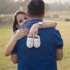 Sometimes the smallest things hold the biggest promises. This playful outdoor shot, with those tiny shoes, is all about the sweet, fun moments you share while waiting for your little one's arrival.
