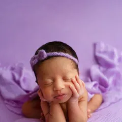 The final result of a 'froggy pose', where the baby appears to be resting their chin on their hands. This is a composite image created with full support for the baby at all times.