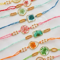 A colorful lineup of my preserved flower rakhis, showcasing the different shapes, flowers, and thread colors available.
