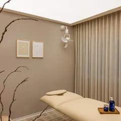 We designed the treatment rooms to be sanctuaries of calm. The space is defined by a neutral color palette, soft, indirect lighting from a stretch ceiling, and heavy curtains that ensure privacy and absorb sound, creating an ideal environment for relaxation.