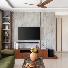 After: The same wall transformed with a textured grey finish, a rich walnut media unit, and integrated shelving. This shows the complete change my turnkey process delivers.