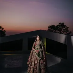 An artistic bridal portrait against the dramatic twilight sky. I use light and shadow to create stunning, magazine-worthy images that highlight the bride's elegance and the grandeur of her attire.