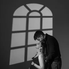 I often use shadows to add depth and emotion. Here, the shadow of a window frame suggests a home, a future, and the new life about to begin, all while keeping the focus on the couple's quiet, intimate connection.