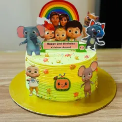 A bright and cheerful Cocomelon cake with a rainbow topper, perfect for a toddler's party.
