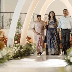 The bride's grand entrance at her Roce ceremony. She walks through a stunning tunnel of modern white arches, a contemporary and elegant design that made the moment truly special.