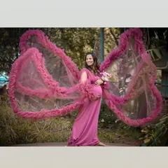 This unique pink gown features dramatic, wing-like sleeves that create a beautiful, ethereal effect in outdoor settings. It's a perfect choice for a fantasy-inspired shoot.