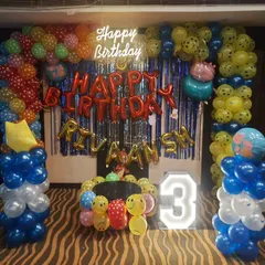 A bright and colorful birthday setup packed with fun elements. This design combines a 'Happy Birthday' neon sign, red foil balloons for the name, a marquee number '3', and columns made of multi-colored and smiley-face balloons.