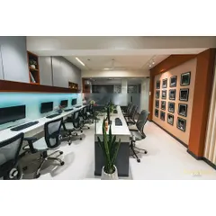 A view of our main workstation area, designed for collaboration and focus. The long desk is complemented by ergonomic chairs and a gallery wall of our proudest project moments.
