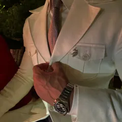 A close-up of a custom safari suit, showing the pocket flap, lapel pin, and the perfect fit around the torso. These details create a look of rugged elegance.