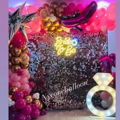 I designed this glamorous 'Bride to Be' party setup for a memorable celebration. It features a dazzling pink sequin wall, a custom neon sign, a light-up diamond ring prop, and a balloon arrangement in shades of pink and rose gold.