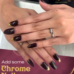 Dark, dramatic, and glamorous. This look features long, almond-shaped nails in a deep, glossy black with a touch of gold chrome at the cuticles for a sophisticated finish.