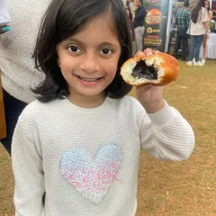A happy smile and a half-eaten chocolate stuffed donut. This is what pure joy looks like at one of my pop-up stalls.