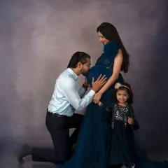 A beautiful family portrait, with the older sister holding a sign and sharing in the excitement. A heartwarming image of a growing family.
