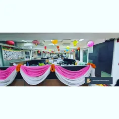 We decorated the office cubicles with pink and white fabric swags, marigold garlands, and colorful paper lanterns. This simple touch brings the festive celebration to every corner of the workspace.