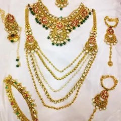 This is a complete bridal rental set laid out to show all the matching pieces. It includes a choker, a multi-layered rani haar, hathphool, earrings, and a maang tikka, all coordinated perfectly.