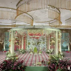 The 'Janavasam' ceremony, marking the groom's arrival, is set against a backdrop inspired by the tree of life. The design uses earthy terracotta and teal tones with handcrafted floral embossed fragments to celebrate this vibrant Tamil tradition.