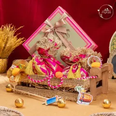 A beautiful Lohri hamper featuring a miniature manji (bedstead) decorated with colourful potlis and a box of sweets. It's a truly unique and traditional gift.