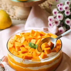 A refreshing bowl of our Mango Cream Cheese Trifle. This dessert layers light cake with a creamy cheese filling and is topped with a generous amount of fresh, juicy mango chunks. It's the taste of summer in a bowl.