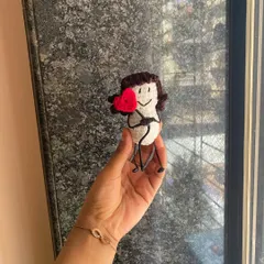 A simple and sweet message doll. This little figure holds a bright red heart, a perfect way to send a little bit of love to someone you care about.