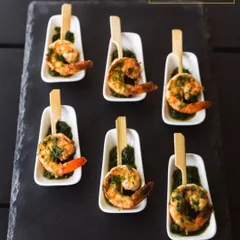These are my pesto-marinated grilled prawns, served on a bed of green chutney. I focus on fresh ingredients and beautiful presentation to create appetisers that are as visually appealing as they are delicious.