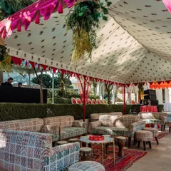 A chic and comfortable lounge area for a Haldi ceremony at The Leela Palace Jaipur. The setup features block-printed sofas and traditional Rajasthani textiles under a tent, blending modern comfort with royal charm.