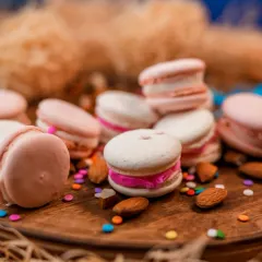 A dreamy pile of our freshly baked macarons. These delicate French cookies have a crisp shell and a chewy interior, filled with a variety of delicious ganaches and buttercreams.