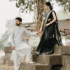 A beautiful moment from a traditional photoshoot. He leads her down the stone steps, a gesture of guidance and partnership.